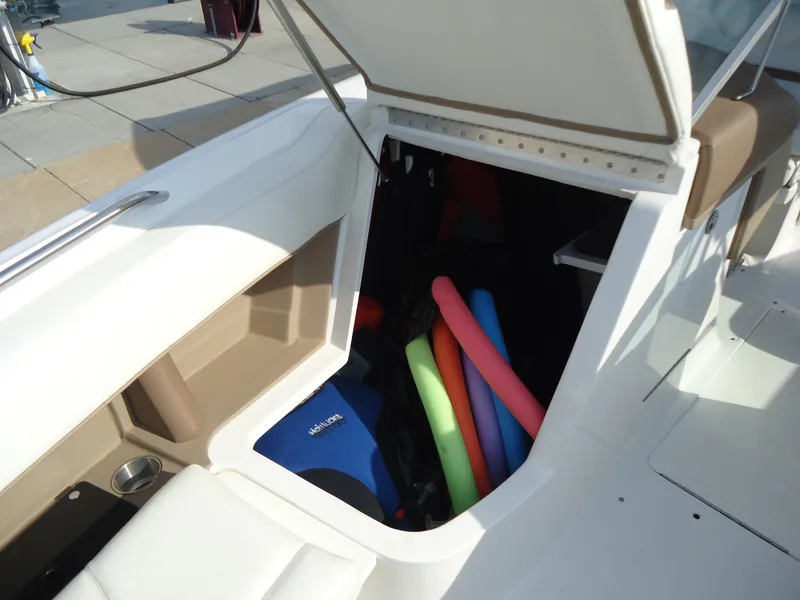 Slide: The Image of 2007 Cobalt 302 boat storage compartment with colorful pool noodles and life jackets. - 24