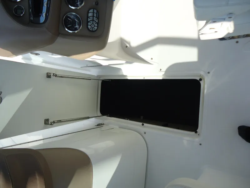 Slide: The Image of 2007 Cobalt 302 boat interior with open storage compartment and control panel. - 25