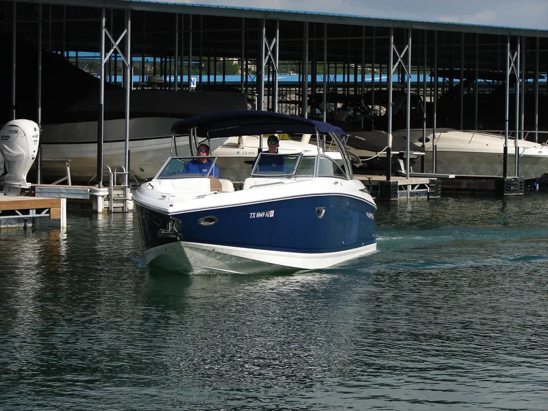 Slide: The Image of 2007 Cobalt 302 boat cruising near a marina with covered docks. - 29