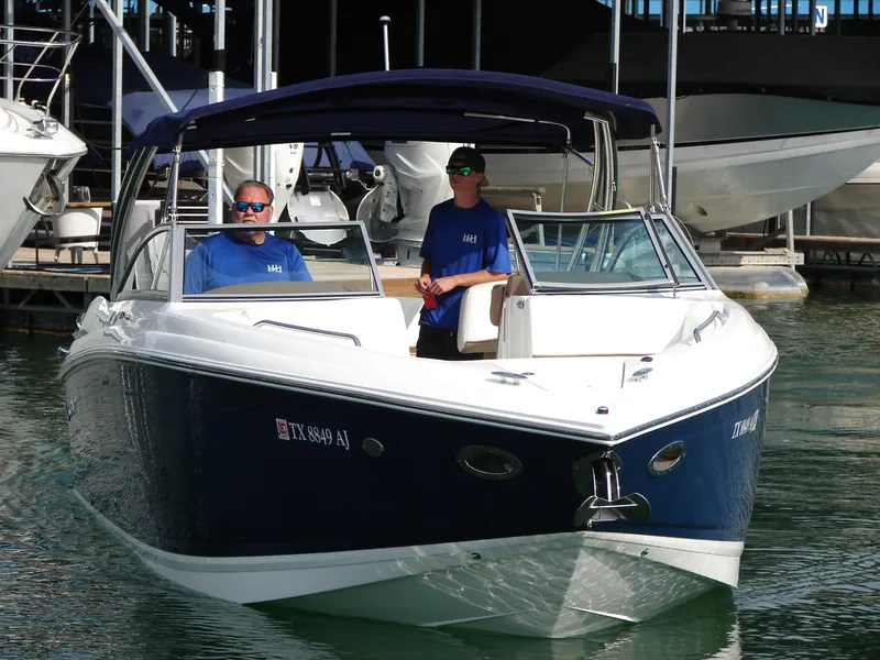 Slide: The Image of 2007 Cobalt 302 boat with two people onboard, docked in a marina. - 31