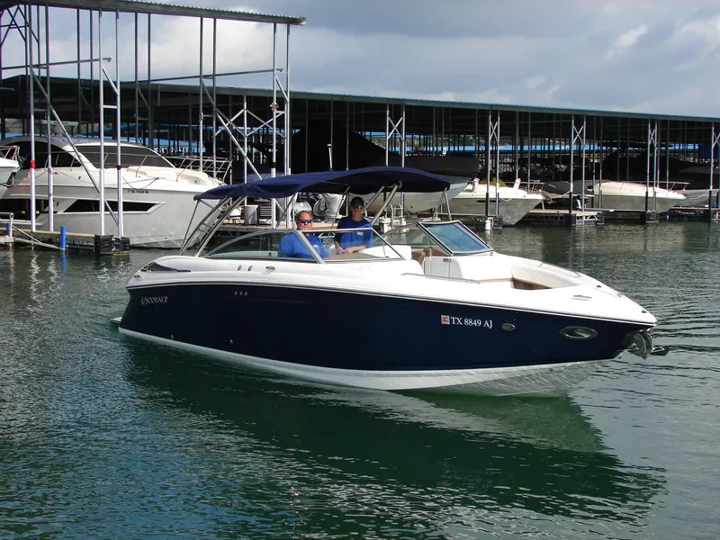 Slide: The Image of 2007 Cobalt 302 boat docked at marina, featuring sleek design and blue hull. - 32
