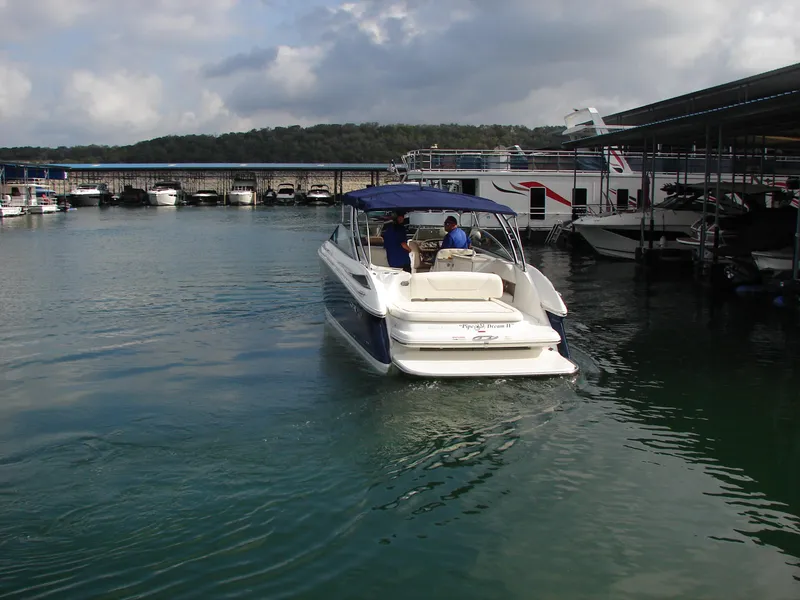 Slide: The Image of 2007 Cobalt 302 boat navigating a marina with calm waters and cloudy skies. - 37