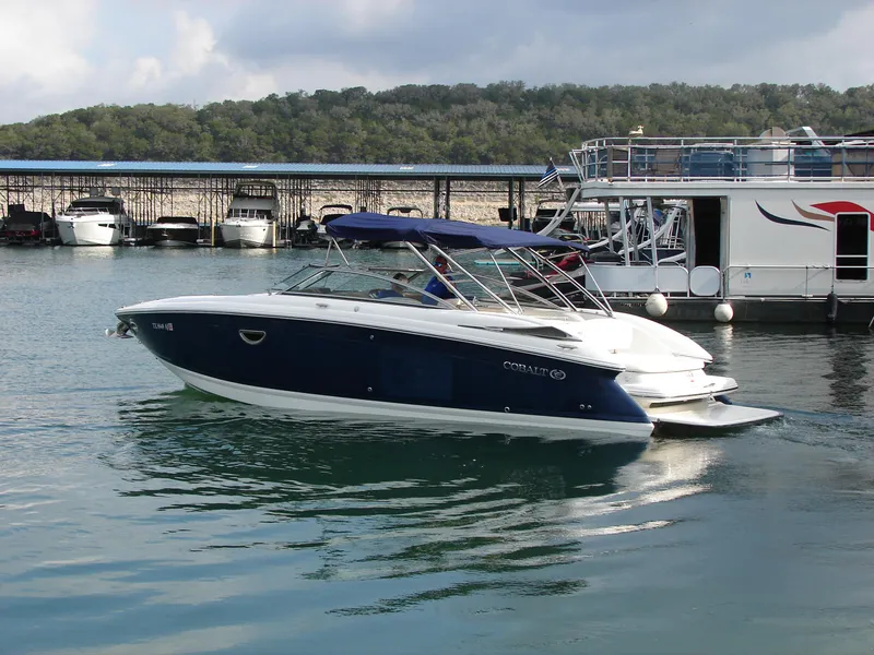 Slide: The Image of 2007 Cobalt 302 boat docked on a calm lake with surrounding hills. - 39