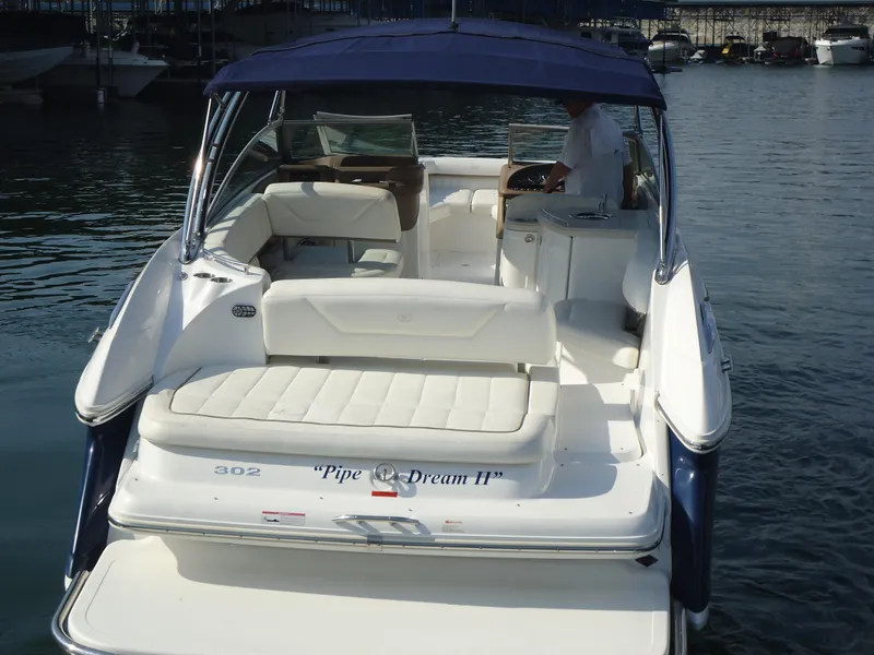 Slide: The Image of 2007 Cobalt 302 boat with blue canopy, docked in marina, featuring spacious seating. - 4