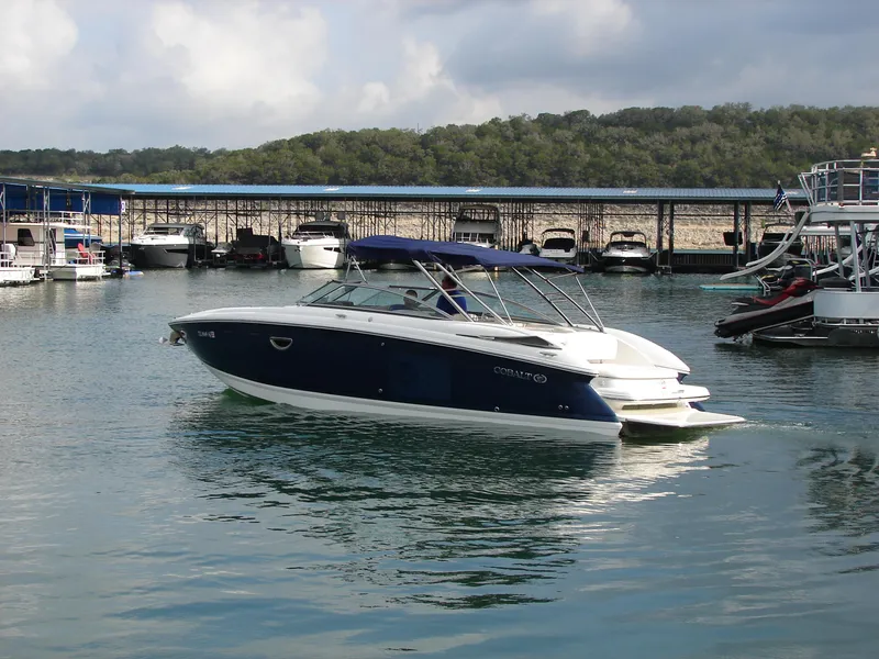 Slide: The Image of 2007 Cobalt 302 boat docked in a marina with scenic background. - 40