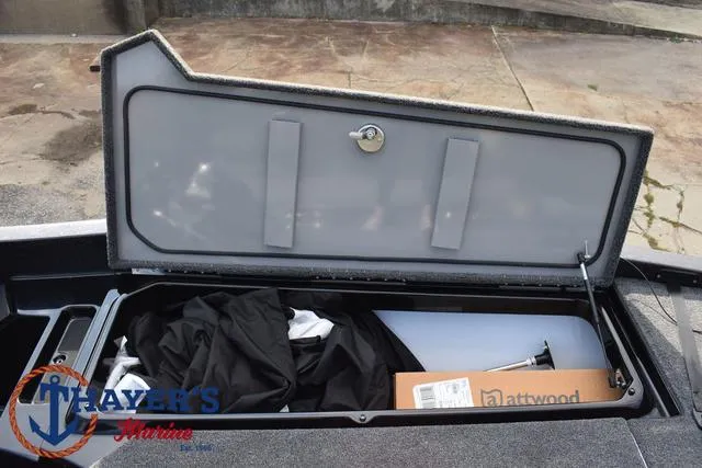 Slide: The Image of Open storage compartment on 2025 Ikon Boats VLX20, featuring various items and Attwood box. - 11