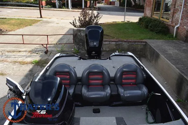 Slide: The Image of 2011 Nitro Z Series Z-6 boat with three seats and motor, parked outdoors. - 11
