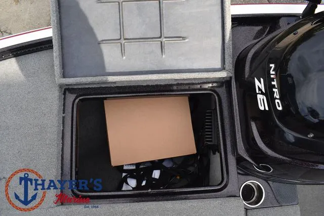 Slide: The Image of Open storage compartment on 2011 Nitro Z Series Z-6 boat with visible engine. - 7
