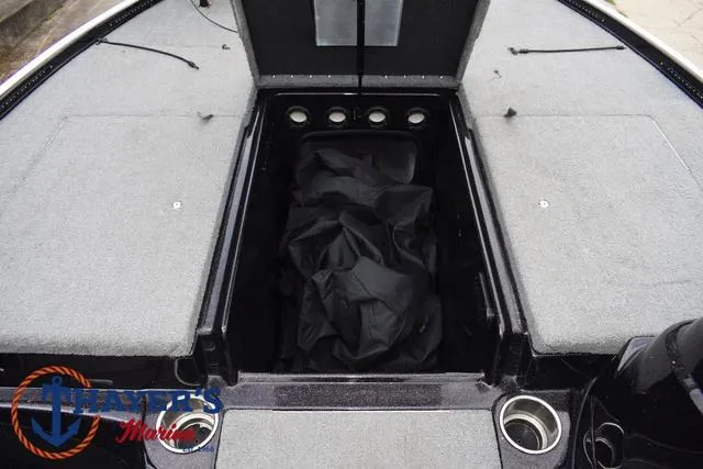 Slide: The Image of 2011 Nitro Z Series Z-6 boat storage compartment with gray carpet and black cover. - 8