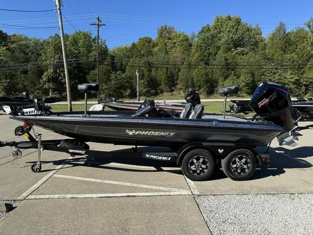 Slide: The Image of 2025 Phoenix 819 ZXL boat on trailer, parked outdoors, surrounded by trees. - 16