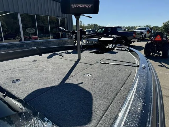 Slide: The Image of 2025 Phoenix 819 ZXL boat deck with fishing equipment, parked outdoors. - 8