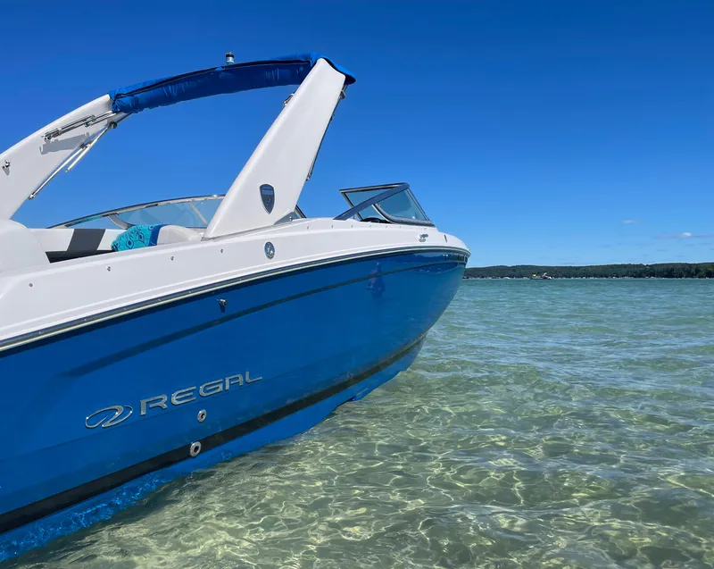 Slide: The Image of 2018 Regal 26 FasDeck boat in clear water under a bright blue sky. - 1