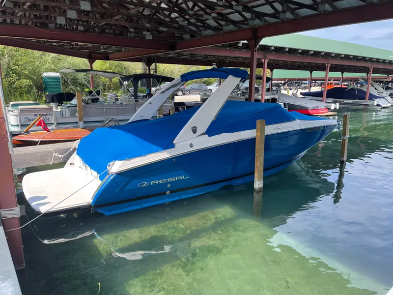Slide: The Image of 2018 Regal 26 FasDeck boat docked under a covered marina. - 2