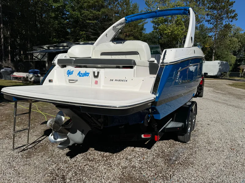 Slide: The Image of 2018 Regal 26 FasDeck boat on trailer, blue and white, parked outdoors. - 4