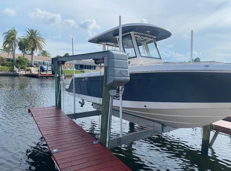Slide: The Image of 2021 Robalo R272 Center Console boat on lift by waterfront dock. - 4