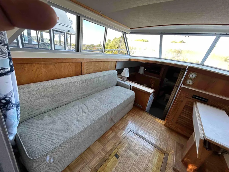 Slide: The Image of Interior of 1986 Silverton 31 Convertible boat with sofa and wooden accents. - 10