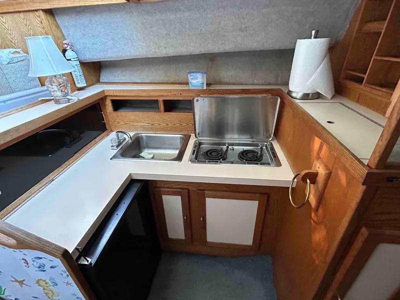 Slide: The Image of 1986 Silverton 31 Convertible kitchen with stove, sink, and wooden cabinetry. - 12