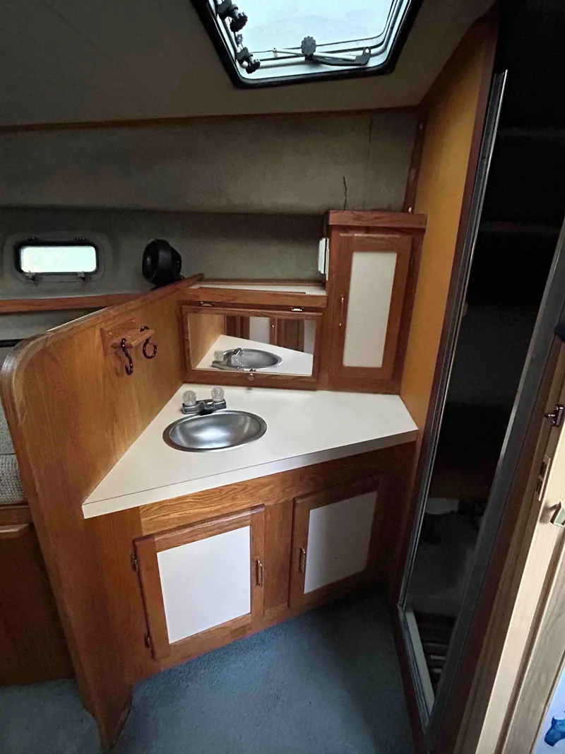 Slide: The Image of 1986 Silverton 31 Convertible boat interior with compact sink and wooden cabinetry. - 14