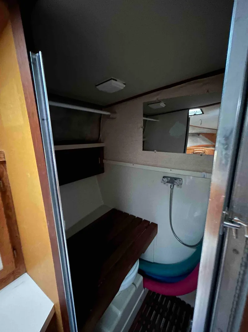 Slide: The Image of 1986 Silverton 31 Convertible boat interior with shower and wooden shelves. - 17