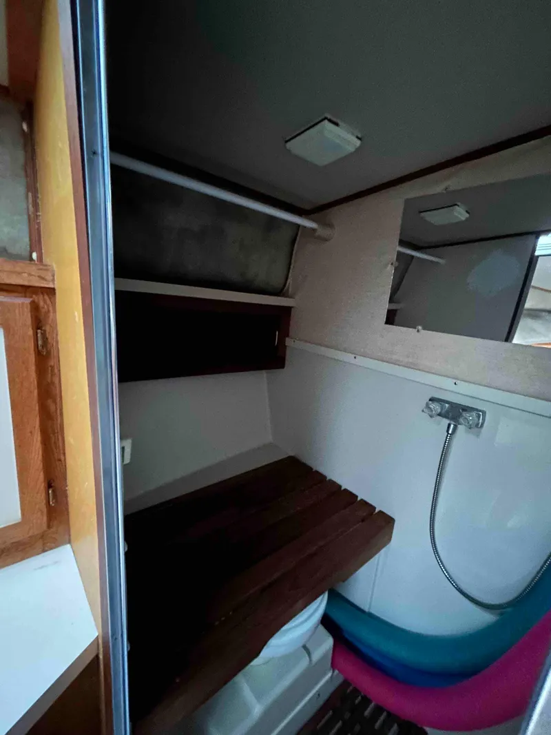 Slide: The Image of 1986 Silverton 31 Convertible boat bathroom with shower and wooden seat. - 18
