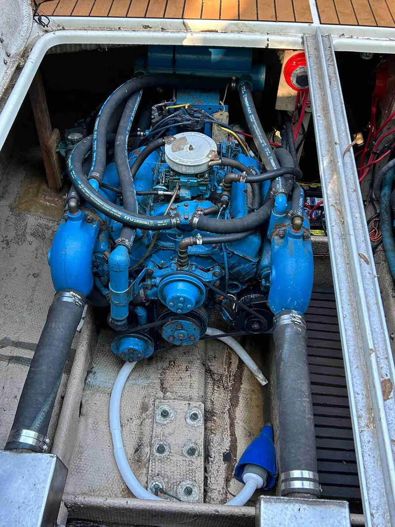 Slide: The Image of 1986 Silverton 31 Convertible engine compartment with blue marine engine and hoses. - 22