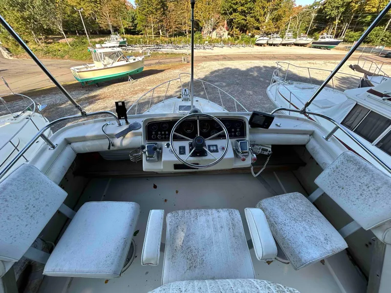 Slide: The Image of 1986 Silverton 31 Convertible boat cockpit with steering wheel and seating, docked outdoors. - 4