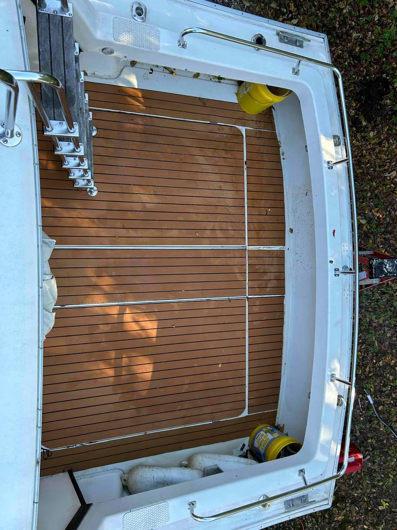 Slide: The Image of 1986 Silverton 31 Convertible boat deck with wooden flooring and ladder. - 8