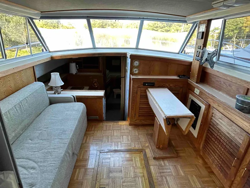 Slide: The Image of 1986 Silverton 31 Convertible interior with wood paneling, sofa, and table. - 9