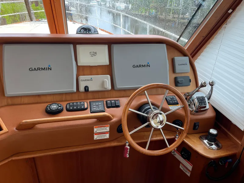 Slide: The Image of 2013 Sabre 48 Salon Express helm with Garmin navigation displays and classic wooden steering wheel. - 12