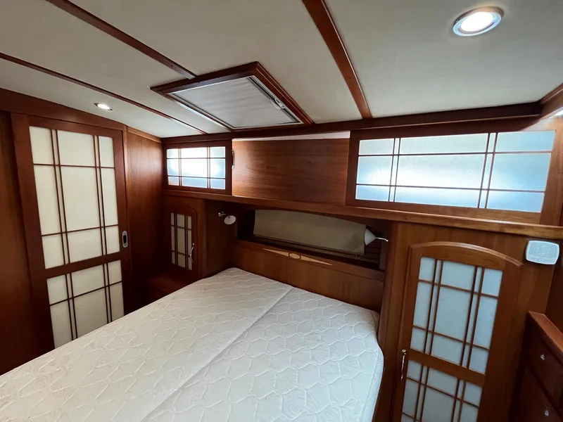 Slide: The Image of 2013 Sabre 48 Salon Express bedroom with wood paneling and frosted glass accents. - 48