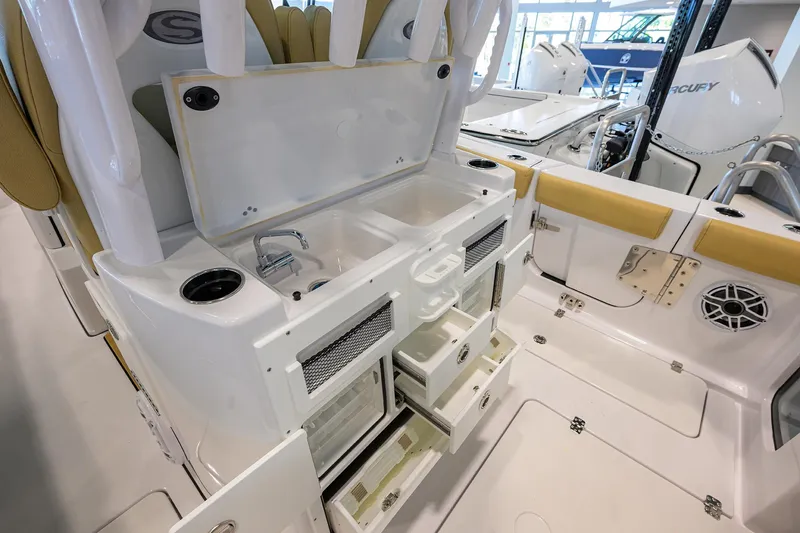 Slide: The Image of 2025 Sportsman Open 282 Center Console boat interior with storage compartments and sink. - 26