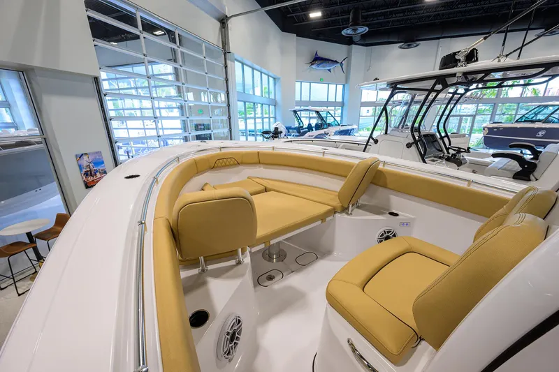Slide: The Image of 2025 Sportsman Open 282 Center Console boat interior with tan seating in showroom. - 6