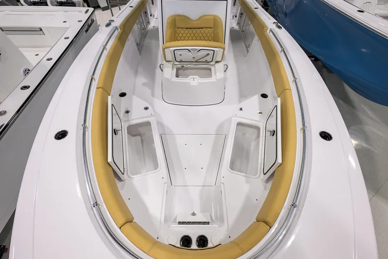 Slide: The Image of 2025 Sportsman Open 282 Center Console boat interior with tan seating and storage compartments. - 9