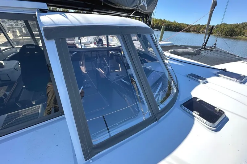 Slide: The Image of 2007 Morrelli & Melvin Shooting Star yacht with sleek windows, docked by a serene river. - 14