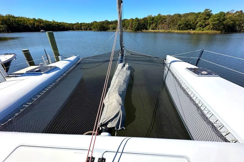 Slide: The Image of 2007 Morrelli & Melvin Shooting Star catamaran on tranquil water, featuring netted deck area. - 17