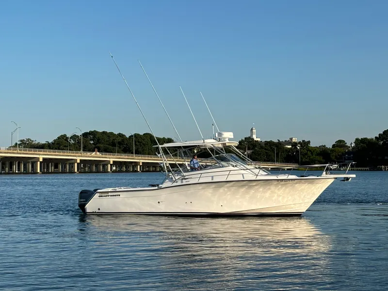 Slide: The Image of 2002 Grady-White 33 Express boat on calm water near a bridge. - 0