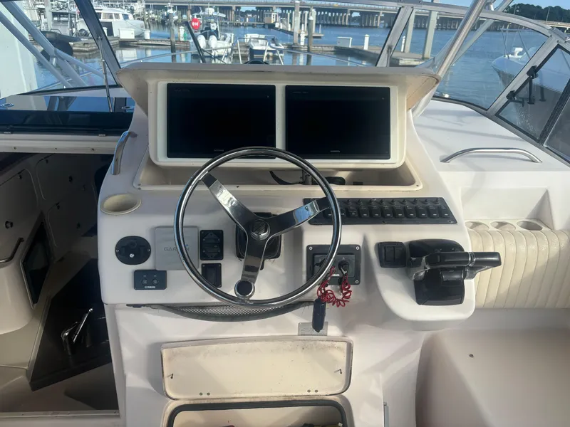 Slide: The Image of 2002 Grady-White 33 Express boat helm with steering wheel and navigation screens. - 4