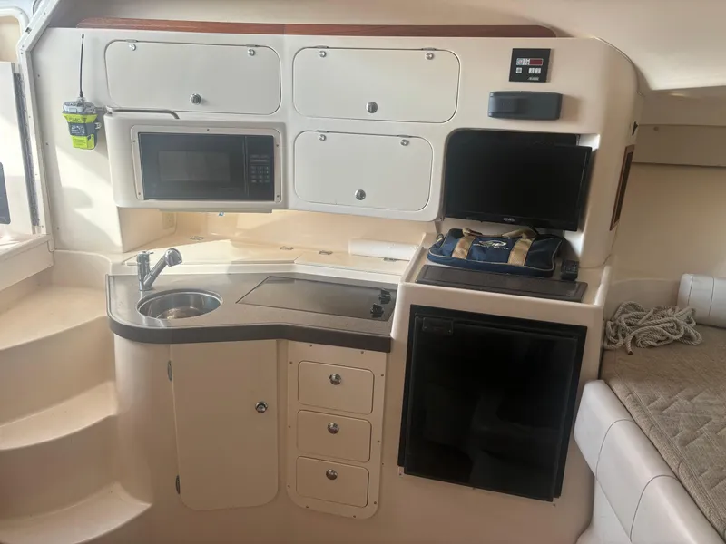 Slide: The Image of 2002 Grady-White 33 Express boat interior with kitchenette, microwave, sink, and storage cabinets. - 7