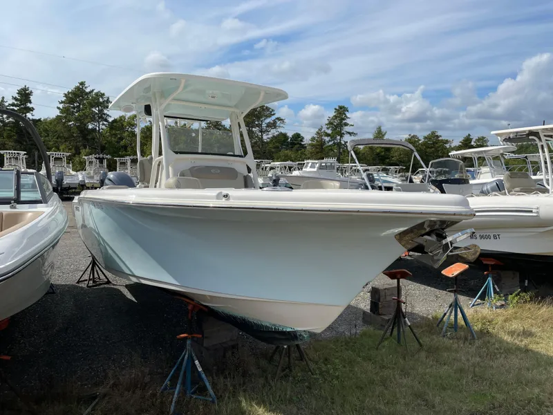 Slide: The Image of 2022 Key West 263 FS boat on stands, surrounded by other boats, under a partly cloudy sky. - 2