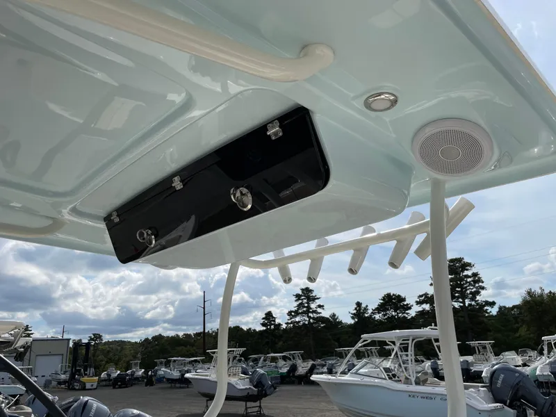 Slide: The Image of 2022 Key West 263 FS boat with rod holders and speaker, docked under cloudy sky. - 8
