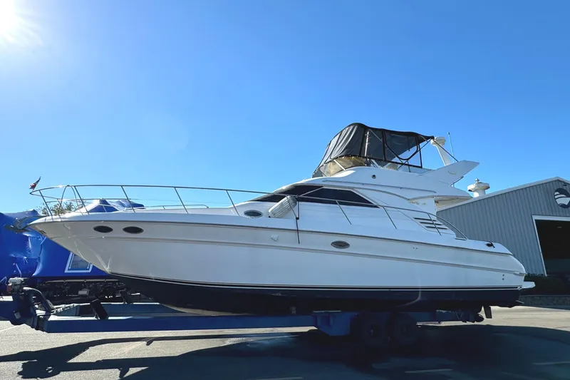 The Image of 1996 Sea Ray 400 Sedan Bridge yacht on trailer under clear blue sky. - 0