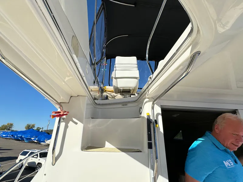 Slide: The Image of 1996 Sea Ray 400 Sedan Bridge yacht with flybridge and man in blue shirt. - 12
