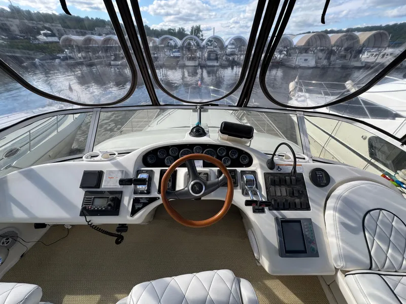 Slide: The Image of 1996 Sea Ray 400 Sedan Bridge helm with wood steering wheel and modern controls. - 16
