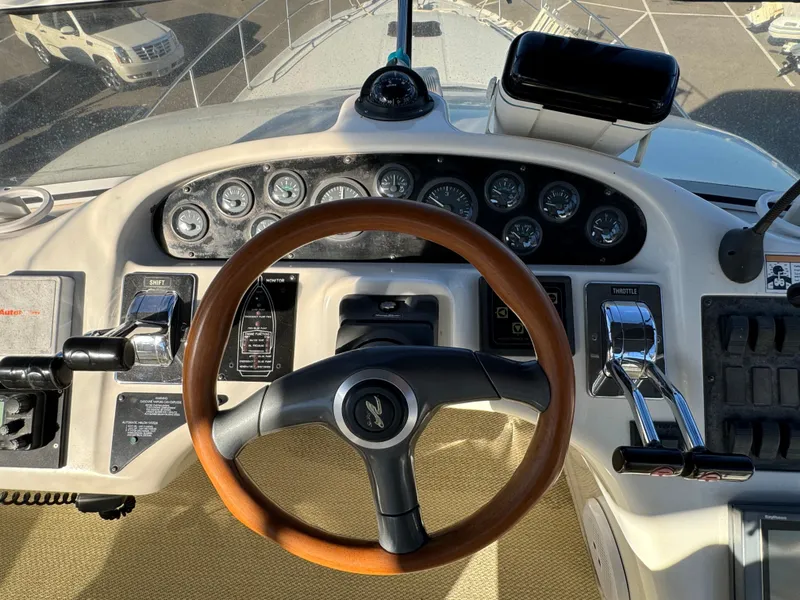 Slide: The Image of 1996 Sea Ray 400 Sedan Bridge helm with wooden steering wheel and control panel. - 17