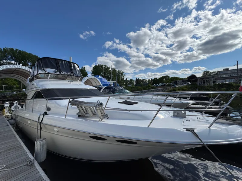 Slide: The Image of 1996 Sea Ray 400 Sedan Bridge yacht docked under a partly cloudy sky. - 3