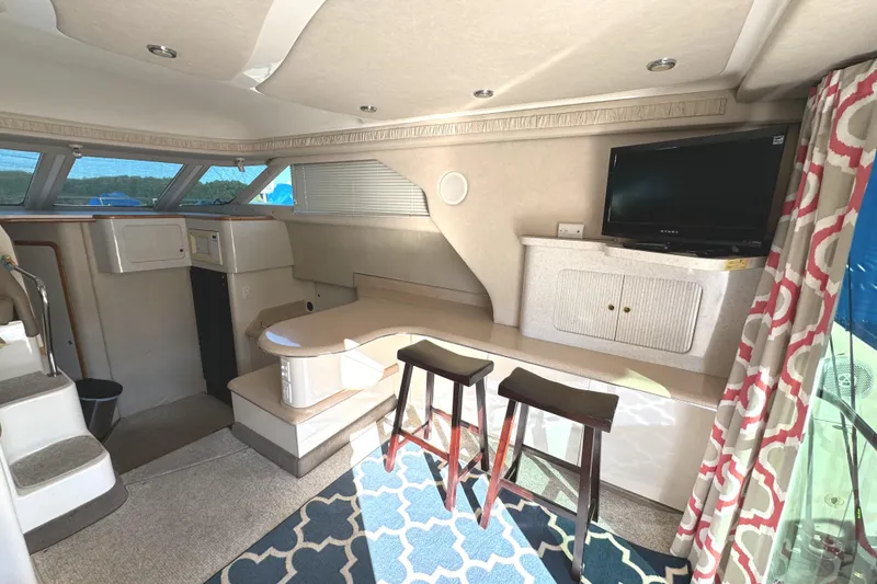 Slide: The Image of Interior of 1996 Sea Ray 400 Sedan Bridge with seating, TV, and nautical decor. - 32