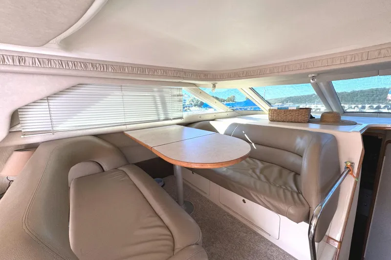 Slide: The Image of Interior of 1996 Sea Ray 400 Sedan Bridge with beige seating and dining table. - 36