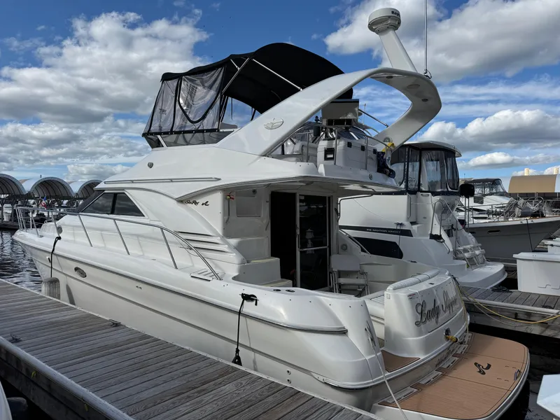 Slide: The Image of 1996 Sea Ray 400 Sedan Bridge docked at marina under cloudy sky. - 4