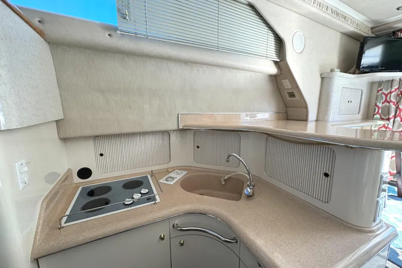 Slide: The Image of 1996 Sea Ray 400 Sedan Bridge kitchen with stove, sink, and storage cabinets. - 40