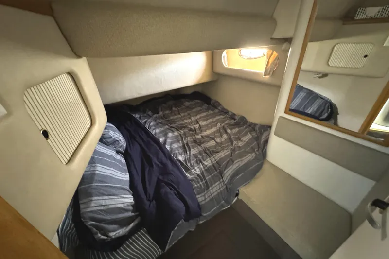 Slide: The Image of Cozy cabin interior of 1996 Sea Ray 400 Sedan Bridge with striped bedding. - 44